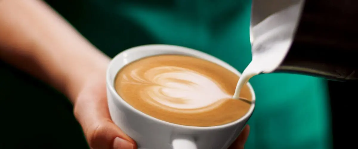 Barista making latte art in cup