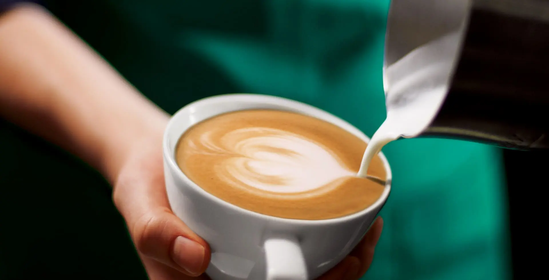 Barista making latte art in cup